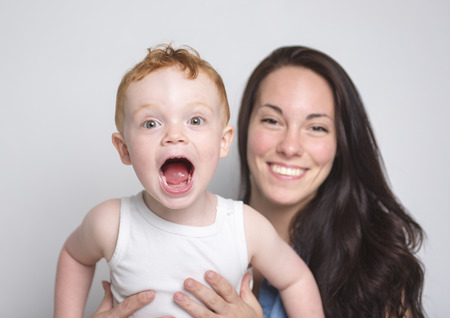 A redhead baby boy with his mother over a isolated white backgroundの写真素材