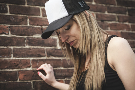 A Beautiful modern girl near the brickwall.の写真素材