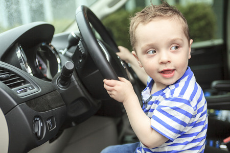 A Cute little boy driving is fathers carの写真素材
