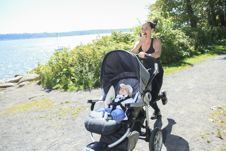 A Young mother jogging with a baby buggyの写真素材