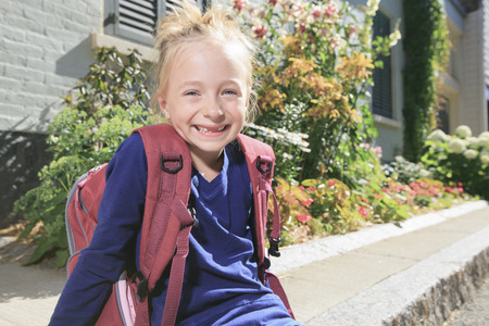A Happy little girl outside with backpack
