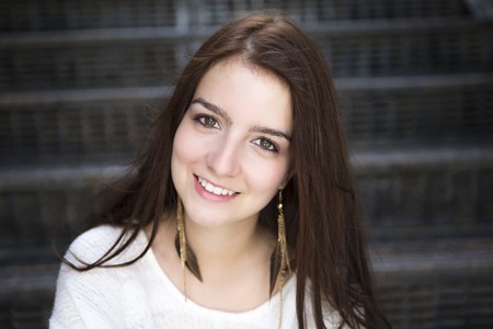 A Young pretty stylish woman sitting on stairsの写真素材