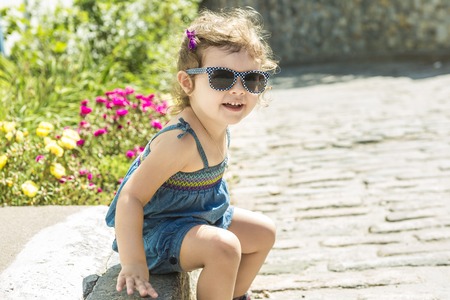 A Little girl in an urban setting smiles at the camera.の写真素材