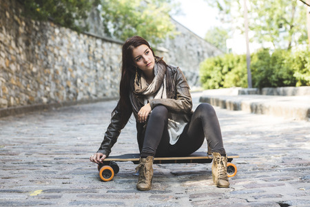 A Beautiful young woman posing with a skateboardの写真素材