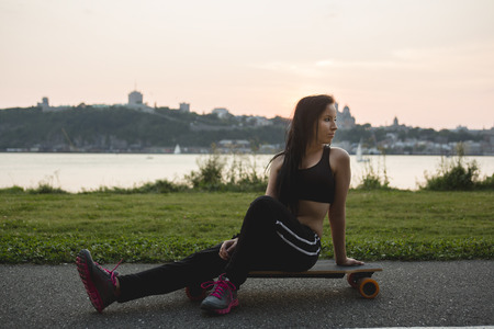 A Beautiful young woman posing with a skateboardの写真素材