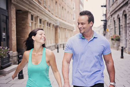 A urban couple on a street having funの写真素材