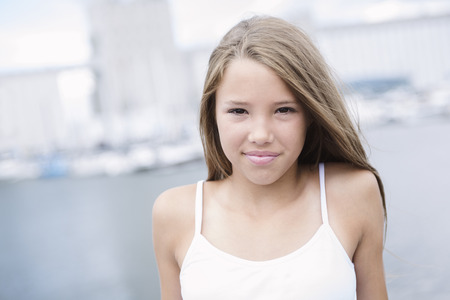 A Young long-haired teen girl standing on the beachの写真素材