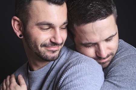 A gay couple on black background studioの写真素材