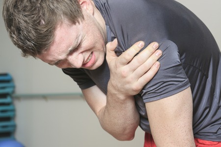 A Portrait of a fitness man reaching for his knee in pain