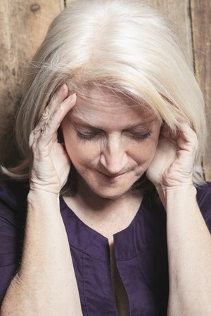 A depress senior person with wood backgroundの写真素材