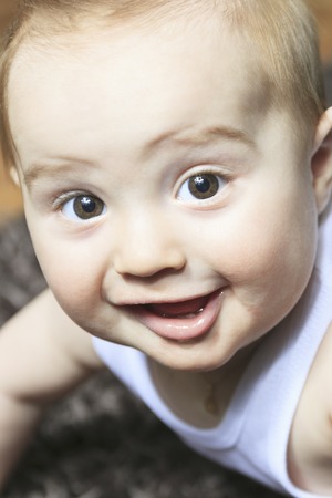 A 7 months baby boy smiling on floor