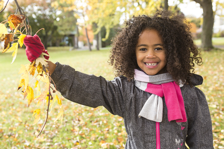 A Child on autumn season portrait having fun outsideの写真素材