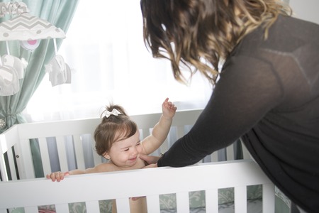 An Infant baby resting and playing in his little baby bedの写真素材