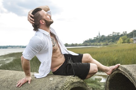 A sexy man with tattoo outside taking good timeの写真素材