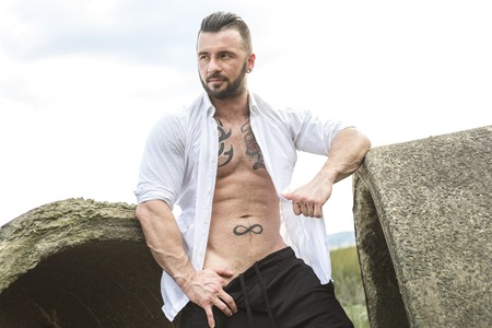 A sexy man with tattoo outside taking good timeの写真素材