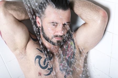 A sexy man with tattoo  on the showerの写真素材