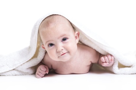 A Three month baby under white towel isolated on whiteの写真素材