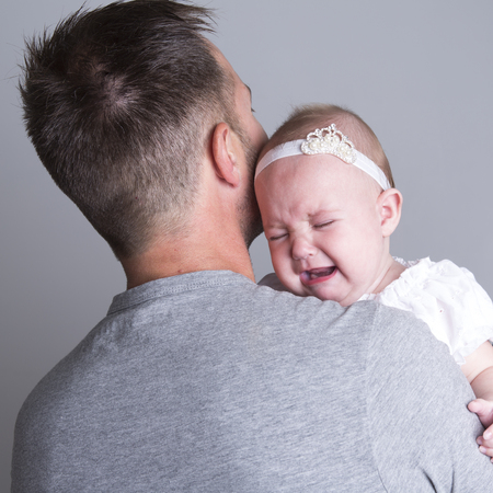 A baby who cry on the hand of is fatherの写真素材
