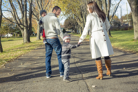 A Family Walking Along Autumn Pathの写真素材