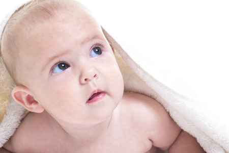 A Three month baby under white towel isolated on white