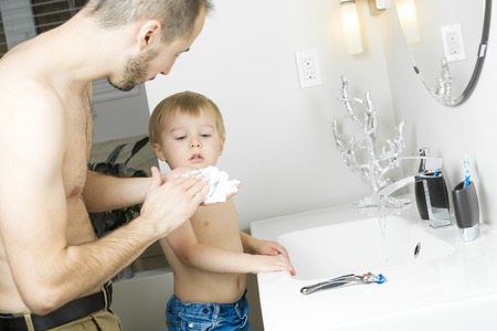 A Man in bathroom with child ready to shaveの写真素材