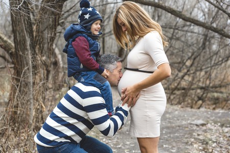 A beautiful outdoor pregnant couple portrait in autumn natureの写真素材