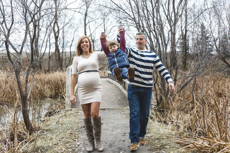A beautiful outdoor pregnant couple portrait in autumn natureの写真素材