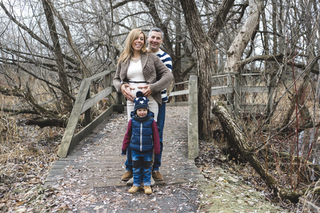 A beautiful outdoor pregnant couple portrait in autumn natureの写真素材