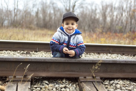 An adorable portrait of a boy on a railway stationの写真素材