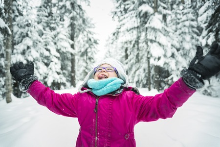 A Little Girl Playing with Snow Outdoors in Winterの写真素材
