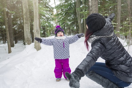A Mother and daughter having fun in the winter parkの写真素材