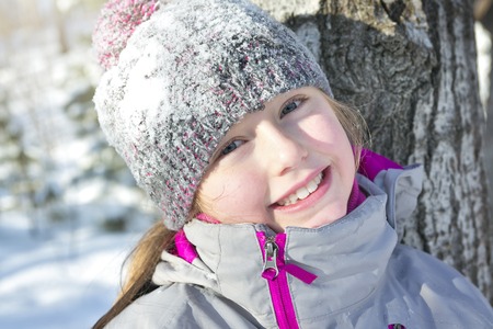 A Little girl in winter season with hat in snow.