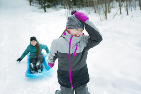 Two Children Pulling Sledge Through Snowy Landscape