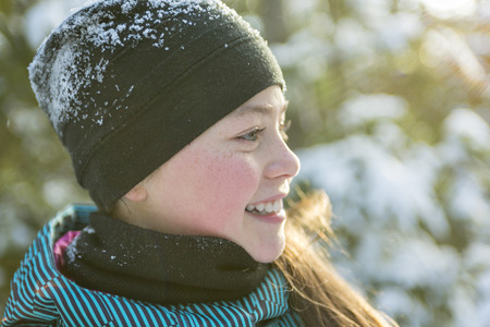 A Little girl in winter season with hat in snow.