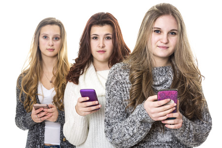 Three attractive teen girls using ellphonesの写真素材