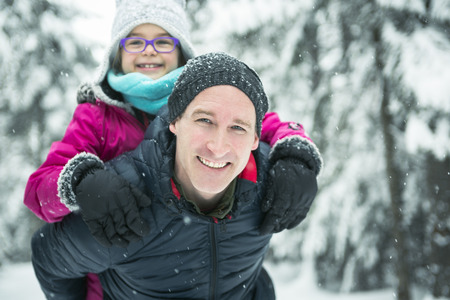 A Father and daughter enjoying snow at daytime