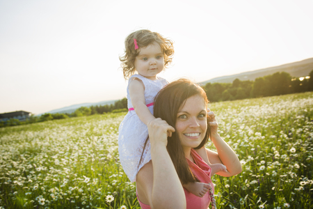 A happy joyful mother with daughter on sunsetの写真素材