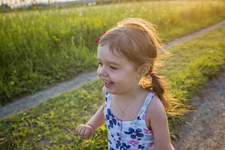 A Girl running on the field at summer sunsetの写真素材