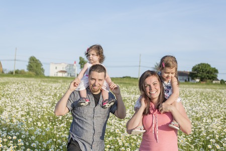 A happy joyful family in daisy sunset timeの写真素材