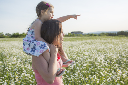 A happy joyful mother with daughter on sunsetの写真素材