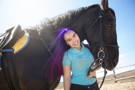 A Beautiful teen girl on the farm with her horse.の写真素材