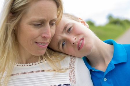 A teen with son head on the shoulderの写真素材