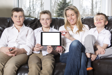 An attractive happy, family of mother, son sitting on sofaの写真素材