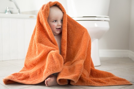 An Adorable baby boy playing with toilet paperの写真素材