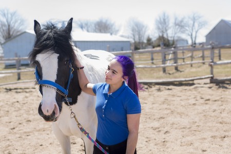 A Beautiful teen girl on the farm with her horse.の写真素材