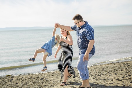 A Family of three on beach having fun togetherの写真素材