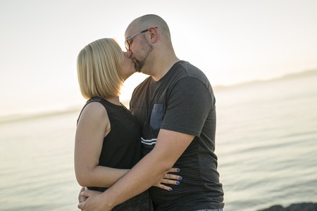 A Beautiful couple at the sunset habing fun on seaside