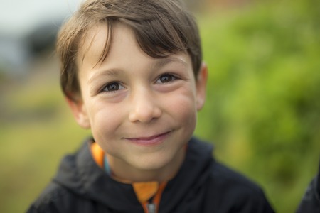 A boy close to the grass at sunset