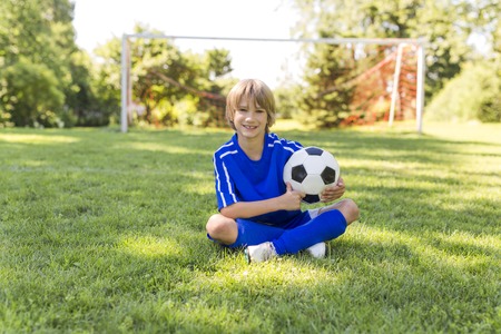 Young boy with soccer ball on a sport uniformの写真素材