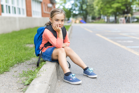 A eight years old school girl close to the schoolyardsの写真素材